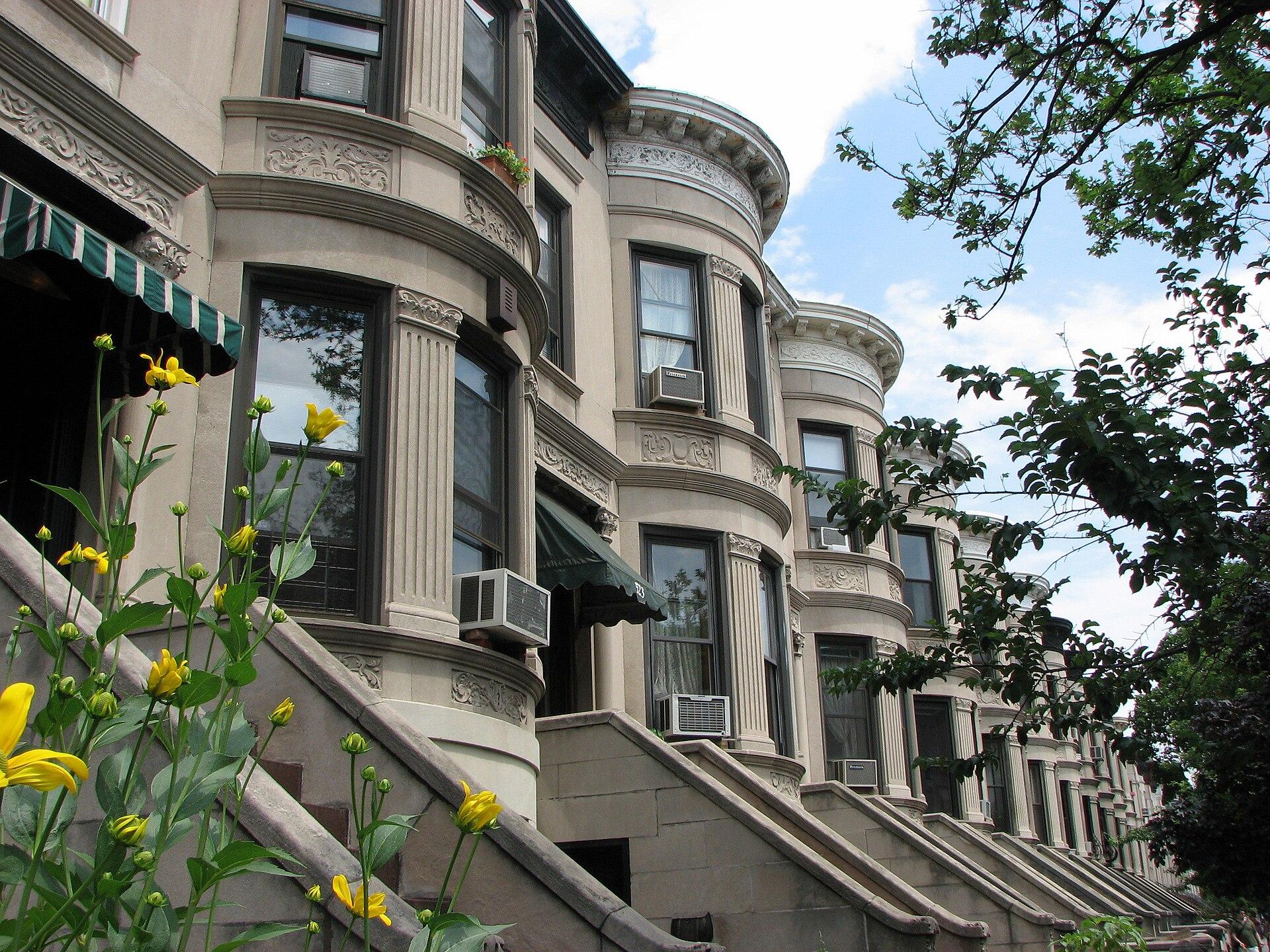 A row of Park Slope brownstone houses with stoops and rounded bay windows